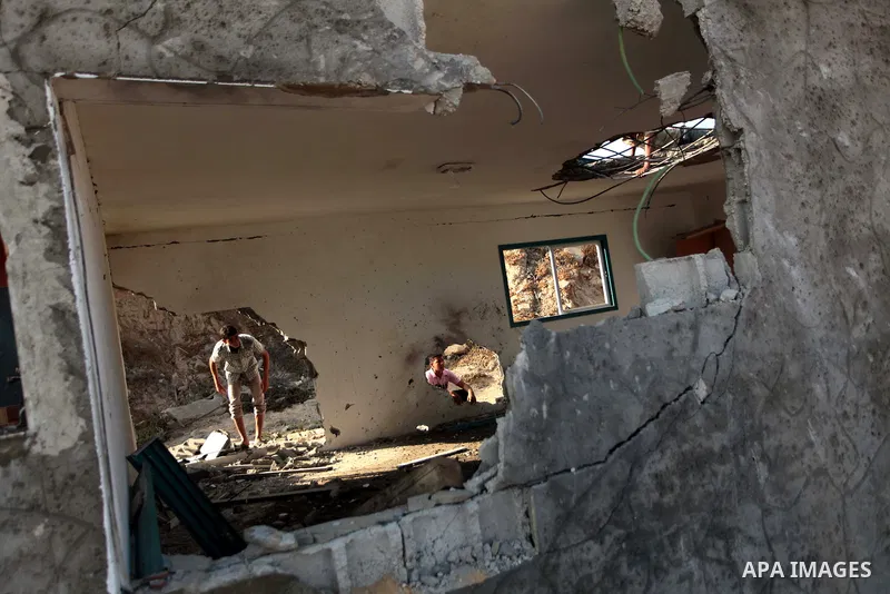 Palestinian men inspect the site of an Israeli air strike in the central Gaza Strip June 25, 2014. Militants in the Gaza Strip, a coastal enclave where Hamas is dominant and has vowed revenge at Israel's crackdown, fired...