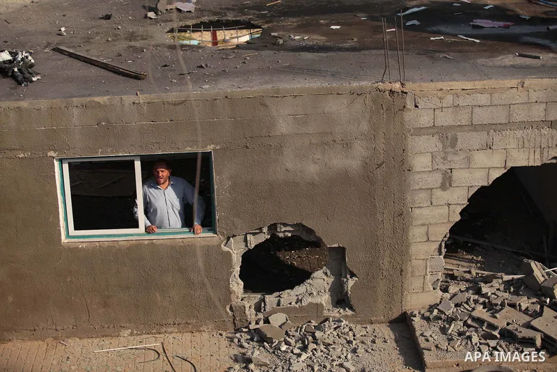 A Palestinian man inspects the site of an Israeli air strike in the central Gaza Strip June 25, 2014. Militants in the Gaza Strip, a coastal enclave where Hamas is dominant and has vowed revenge at Israel's crackdown, fi...