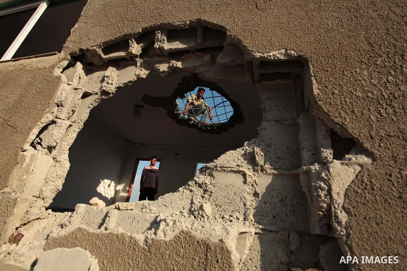 Palestinian men inspect the site of an Israeli air strike in the central Gaza Strip June 25, 2014. Militants in the Gaza Strip, a coastal enclave where Hamas is dominant and has vowed revenge at Israel's crackdown, fired...
