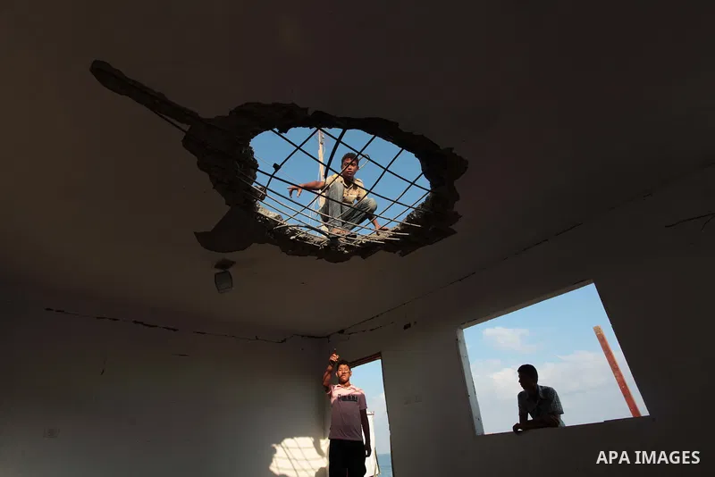 Palestinian men inspect the site of an Israeli air strike in the central Gaza Strip June 25, 2014. Militants in the Gaza Strip, a coastal enclave where Hamas is dominant and has vowed revenge at Israel's crackdown, fired...