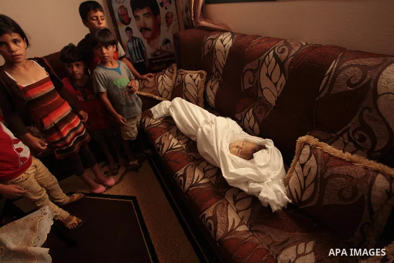 Relatives of three-year-old Palestinian girl Jud al-Danaf gather to bid farewell to her body during her funeral in Gaza City June 25, 2014. The Gaza girl was killed and three of her family were wounded in an explosion wh...
