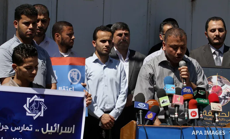 Palestinian journalists hold placards during a protest calling for stop the Israeli violence against journalists in West Bank in front of high commissioner for human rights headquarters, in Gaza City on June 25, 2014. Ph...