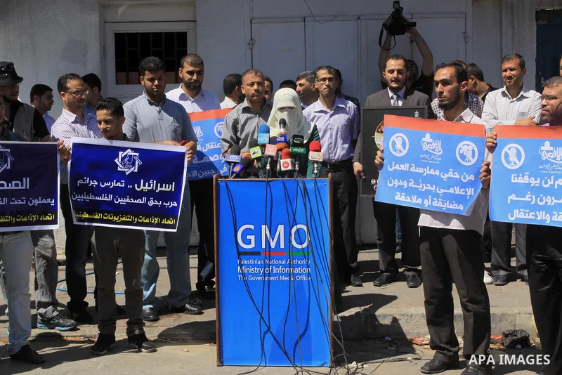 Palestinian journalists hold placards during a protest calling for stop the Israeli violence against journalists in West Bank in front of high commissioner for human rights headquarters, in Gaza City on June 25, 2014. Ph...