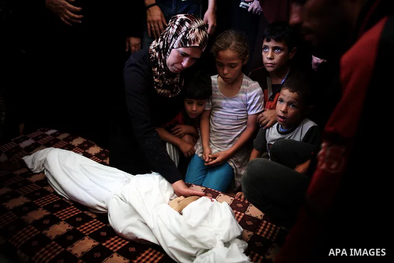 Mourners gather around the body of three-year-old Palestinian girl Jud al-Danaf before her funeral, in Gaza City June 25, 2014. The Gaza girl was killed and three of her family were wounded in an explosion which resident...