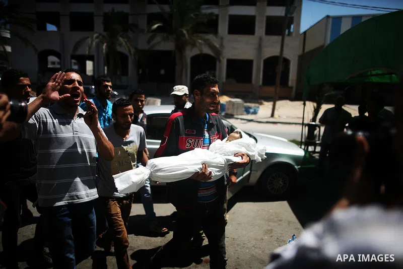 The father of three-year-old Palestinian girl Jud al-Danaf carries her body in Gaza City June 25, 2014. The Gaza girl was killed and three of her family were wounded in an explosion which residents blamed on Israel. The...