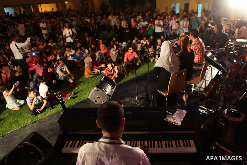 Palestinians take part in a concert in the courtyard of the French Cultural Center in Gaza City, on June 24, 2014. Photo by Ezz Zanoun