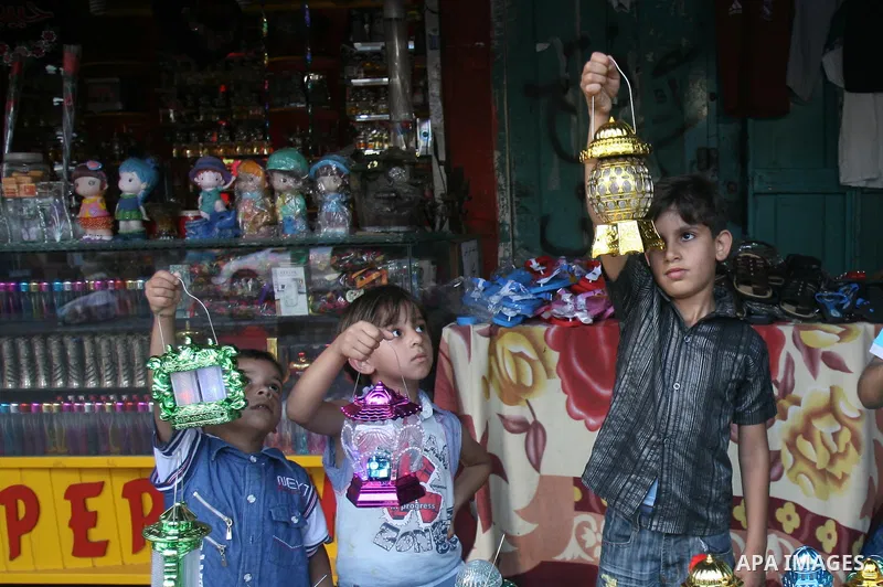 Palestinian children carry traditional Ramadan lanterns marking the holy month of Ramadan at a market in Rafah in the southern Gaza Strip, June 26, 2014. Muslims observe the dawn-to-dusk fasting during the holy month of...