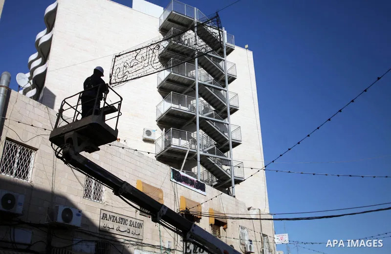 A Palestinian man decorates the street in the old city of Jerusalem on June 26, 2014, as people prepare for the upcoming Muslim holy fasting month of Ramadan. Muslims around the world celebrate Ramadan, the holiest month...