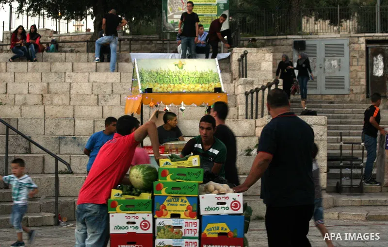 Palestinians shop at a street market in front of Damascus Gate outside the old city of Jerusalem on June 26, 2014, as Muslims prepare for the upcoming holy fasting month of Ramadan. Muslims around the world celebrate Ram...