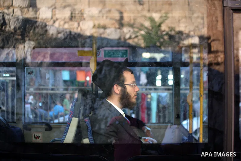Ultra Orthodox Jews ride a bus in front of Damascus Gate outside the old city of Jerusalem on June 26, 2014. Photo by Saeed Qaq