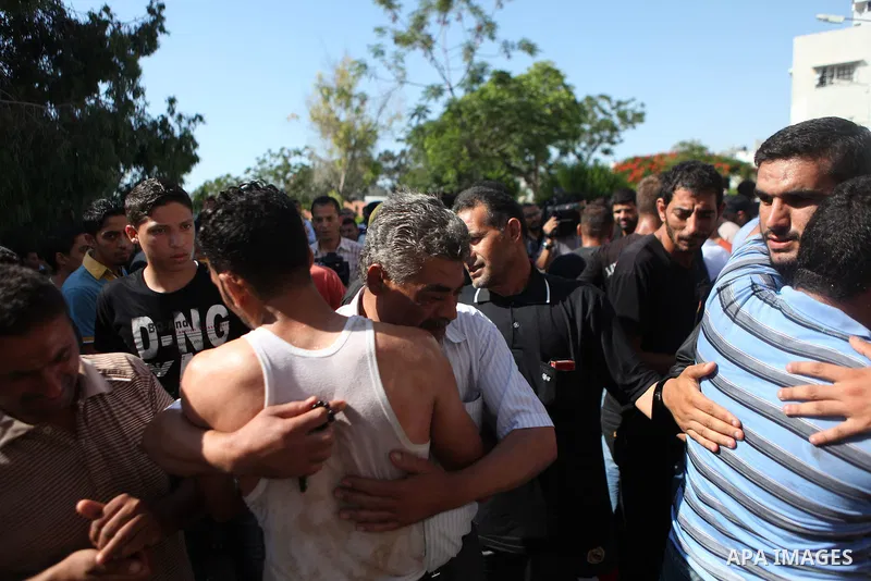 Palestinians inspect the site of an Israeli air strike after targeting a car in Gaza City on June 27, 2014. The air strike killed two Palestinians, medics said, hours after a bomb exploded near troops manning Israel's se...