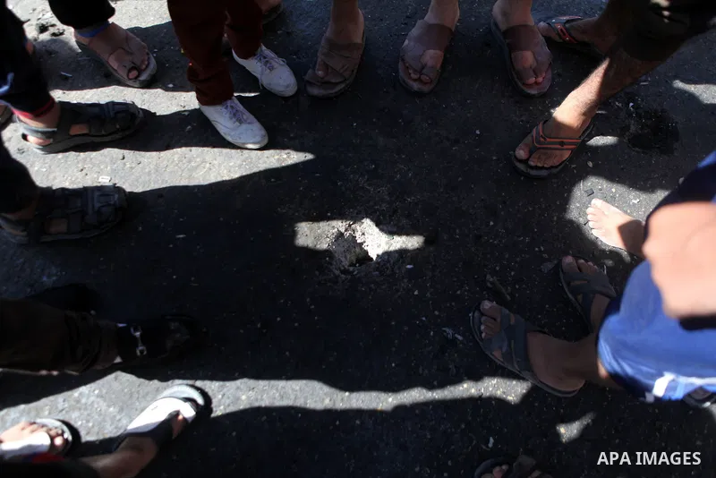 Palestinians inspect the site of an Israeli air strike after targeting a car in Gaza City on June 27, 2014. The air strike killed two Palestinians, medics said, hours after a bomb exploded near troops manning Israel's se...