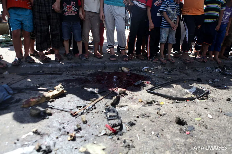 Palestinians inspect the site of an Israeli air strike after targeting a car in Gaza City on June 27, 2014. The air strike killed two Palestinians, medics said, hours after a bomb exploded near troops manning Israel's se...