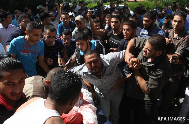 Palestinians mourn the death of two Palestinian militants outside a hospital morgue in Gaza City June 27, 2014. An Israeli air strike killed two Palestinian militants and critically wounded a third in the Gaza Strip on F...