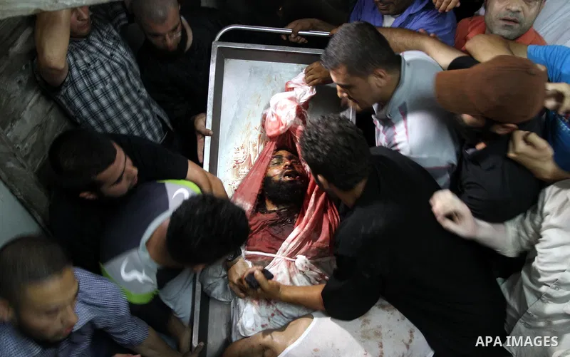 Palestinians mourn around the body of a Palestinian militant at a hospital morgue in Gaza City June 27, 2014. An Israeli air strike killed two Palestinian militants and critically wounded a third in the Gaza Strip on Fri...