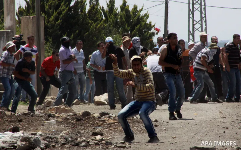 Palestinian protesters throw stones towards Israeli security forces during clashes following a weekly protest against the expropriation of Palestinian land by Israel in the West Bank village of Kfar Qaddum, near Nablus o...