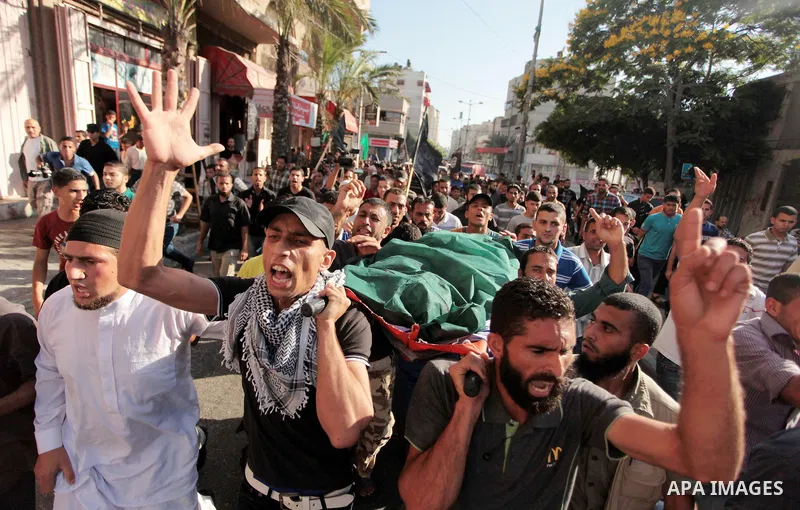 Mourners carry the bodies of Palestinian militant Osama al-Hosomi and Mohammed Fasih during their funeral in Gaza City, June 27, 2014. An Israeli air strike killed two Palestinian militants and critically wounded a third...