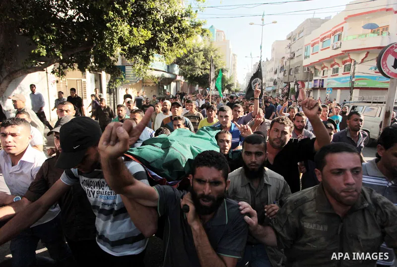 Mourners carry the bodies of Palestinian militant Osama al-Hosomi and Mohammed Fasih during their funeral in Gaza City, June 27, 2014. An Israeli air strike killed two Palestinian militants and critically wounded a third...