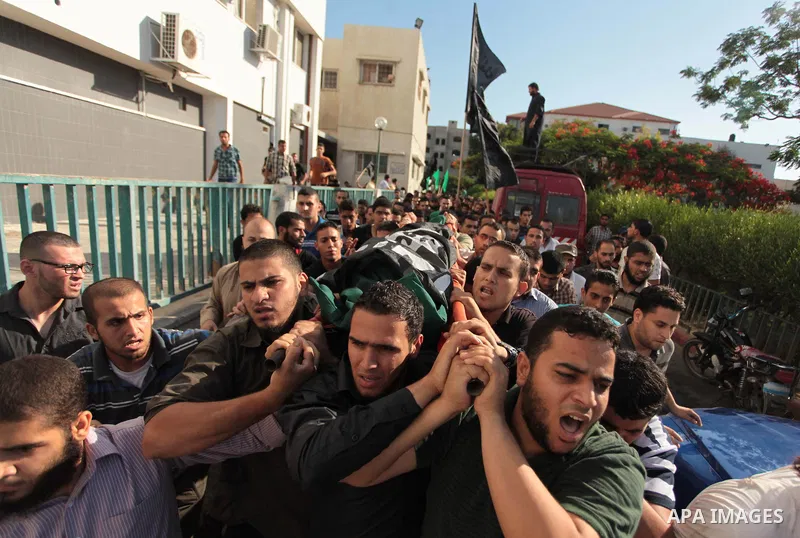 Mourners carry the bodies of Palestinian militant Osama al-Hosomi and Mohammed Fasih during their funeral in Gaza City, June 27, 2014. An Israeli air strike killed two Palestinian militants and critically wounded a third...