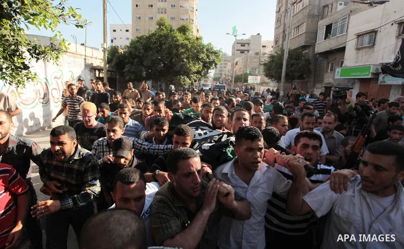 Mourners carry the bodies of Palestinian militant Osama al-Hosomi and Mohammed Fasih during their funeral in Gaza City, June 27, 2014. An Israeli air strike killed two Palestinian militants and critically wounded a third...