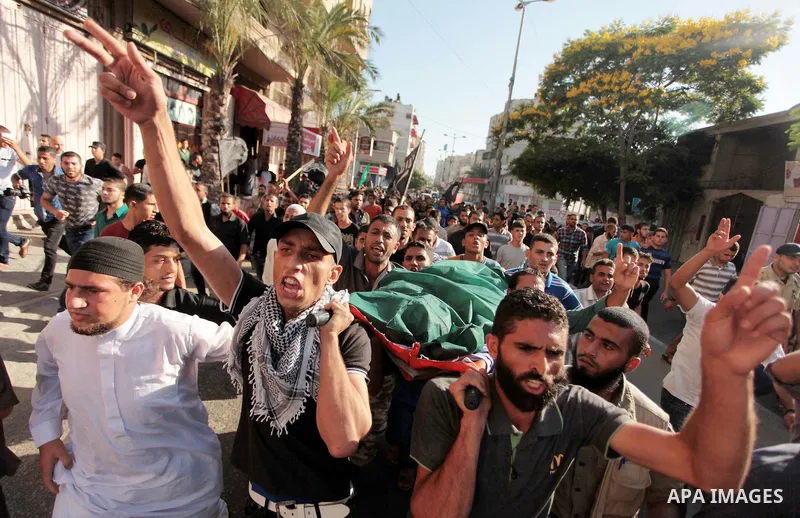 Mourners carry the bodies of Palestinian militant Osama al-Hosomi and Mohammed Fasih during their funeral in Gaza City, June 27, 2014. An Israeli air strike killed two Palestinian militants and critically wounded a third...