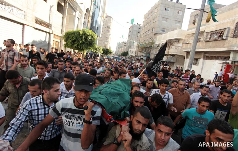 Mourners carry the bodies of Palestinian militant Osama al-Hosomi and Mohammed Fasih during their funeral in Gaza City, June 27, 2014. An Israeli air strike killed two Palestinian militants and critically wounded a third...