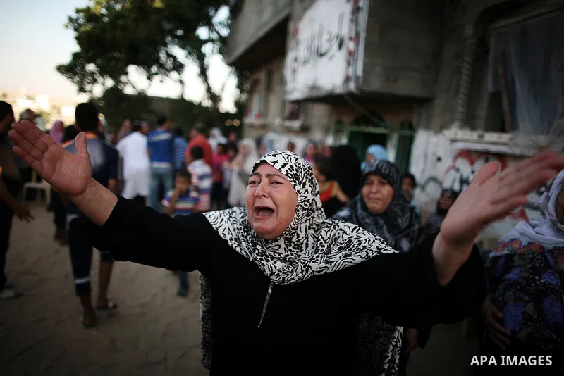 A Palestinian relative of Osama al-Hosomi mourn during his funeral outside his family's house in the northern Gaza Strip June 27, 2014. An Israeli air strike killed two Palestinian militants, one of them al-Hosomi, and c...