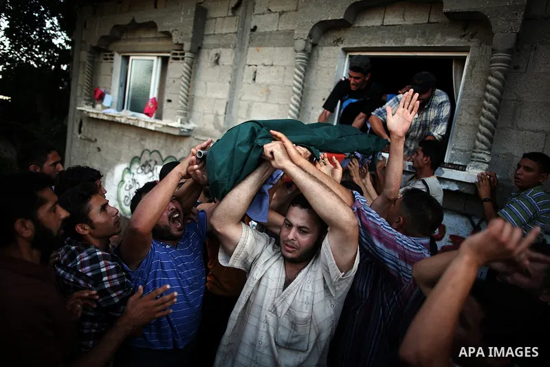 Mourners carry the body of Palestinian militant Osama al-Hosomi during his funeral outside his family's house in the northern Gaza Strip June 27, 2014. An Israeli air strike killed two Palestinian militants, one of them...