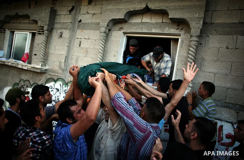 Mourners carry the body of Palestinian militant Osama al-Hosomi during his funeral outside his family's house in the northern Gaza Strip June 27, 2014. An Israeli air strike killed two Palestinian militants, one of them...