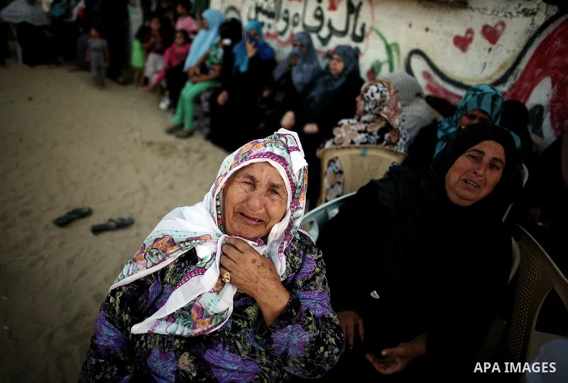 Palestinian relatives of Osama al-Hosomi mourn during his funeral outside his family's house in the northern Gaza Strip June 27, 2014. An Israeli air strike killed two Palestinian militants, one of them al-Hosomi, and cr...