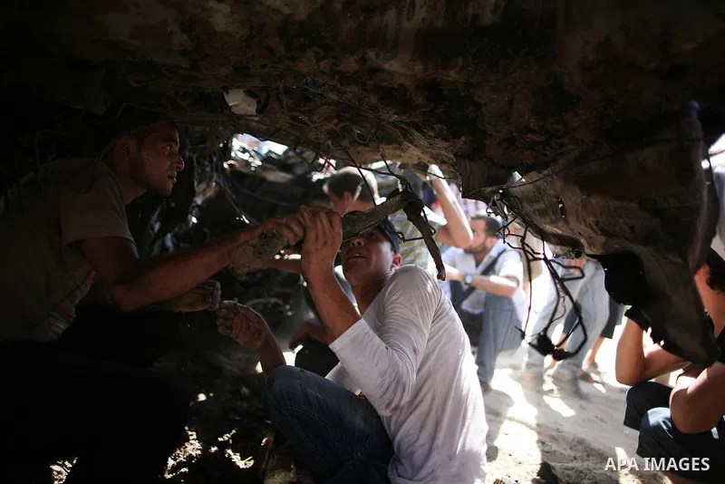 Palestinians inspect a car that was targeted in an Israeli air strike in Gaza City on June 27, 2014. An Israeli air strike killed two Palestinian militants and critically wounded a third in the Gaza Strip on Friday, the...