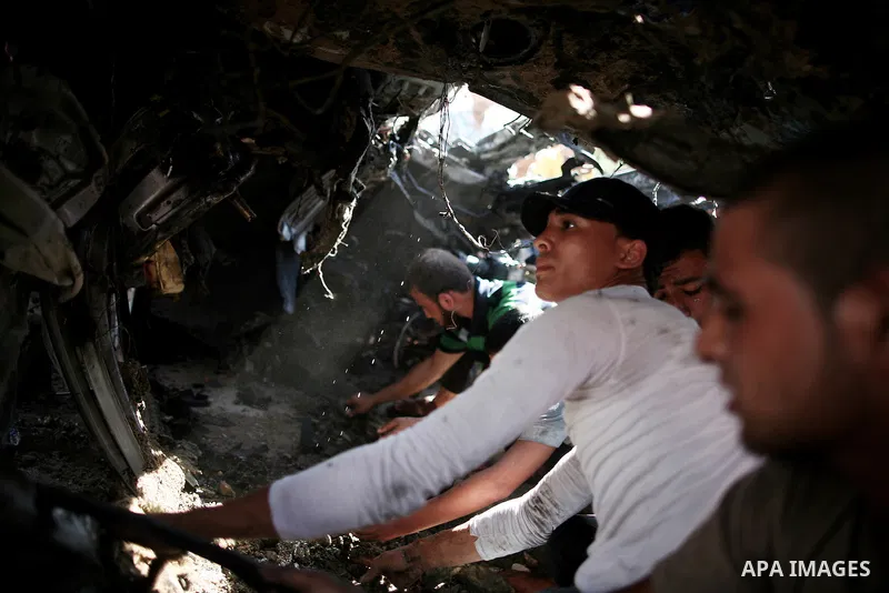 Palestinians inspect a car that was targeted in an Israeli air strike in Gaza City on June 27, 2014. An Israeli air strike killed two Palestinian militants and critically wounded a third in the Gaza Strip on Friday, the...