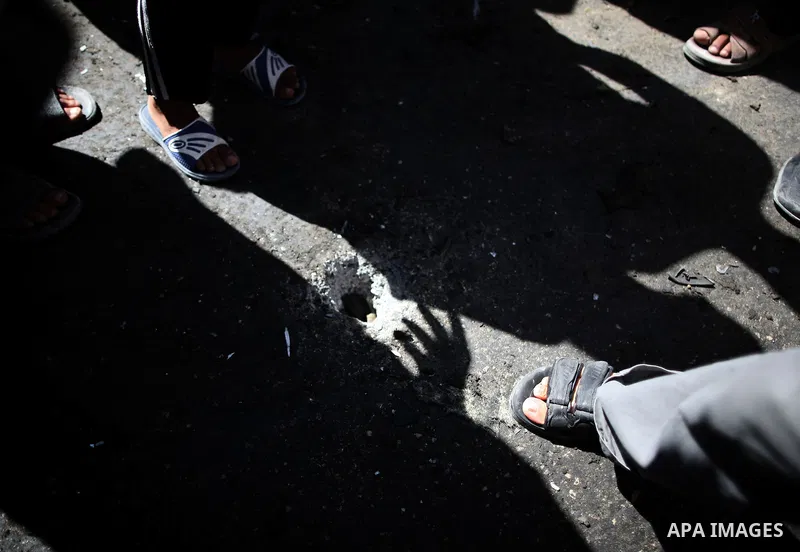 Palestinians inspect the site of a car that was targeted in an Israeli air strike in Gaza City on June 27, 2014. An Israeli air strike killed two Palestinian militants and critically wounded a third in the Gaza Strip on...