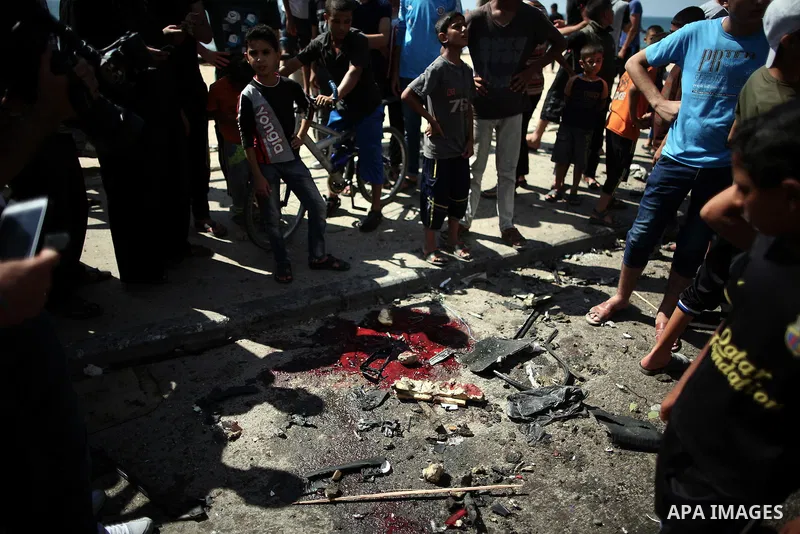 Palestinians inspect the site of a car that was targeted in an Israeli air strike in Gaza City on June 27, 2014. An Israeli air strike killed two Palestinian militants and critically wounded a third in the Gaza Strip on...