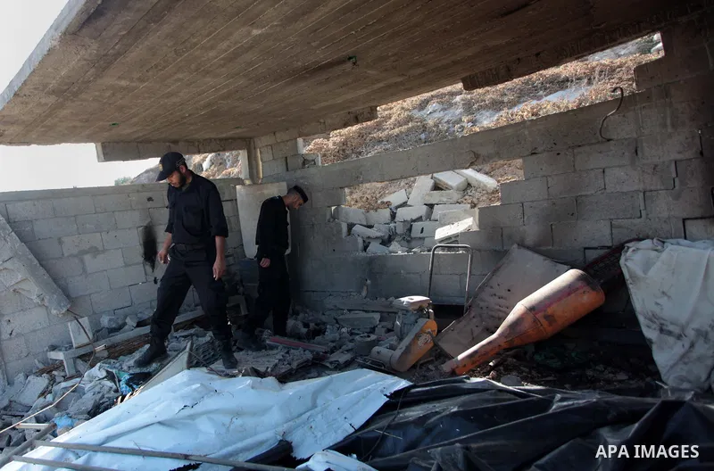 Palestinian security forces inspect the site of an Israeli air strike, in the central Gaza Strip, on June 28, 2014. Israel's army launched airstrikes on southern and central Gaza early Saturday after projectiles fired fr...