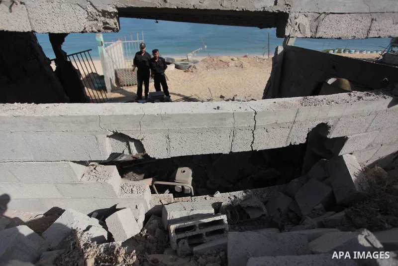 Palestinian security forces inspect the site of an Israeli air strike, in the central Gaza Strip, on June 28, 2014. Israel's army launched airstrikes on southern and central Gaza early Saturday after projectiles fired fr...