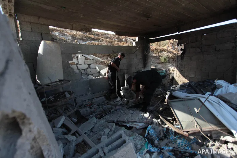 Palestinian security forces inspect the site of an Israeli air strike, in the central Gaza Strip, on June 28, 2014. Israel's army launched airstrikes on southern and central Gaza early Saturday after projectiles fired fr...