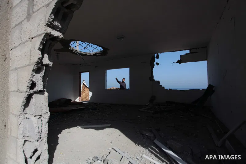A Palestinian security force inspects the site of an Israeli air strike, in the central Gaza Strip, on June 28, 2014. Israel's army launched airstrikes on southern and central Gaza early Saturday after projectiles fired...
