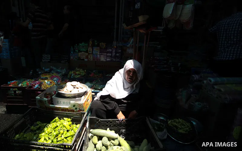 A Palestinian woman sells vegetables and fruits in her shop at a market in Gaza City, as Muslims prepare for the upcoming holy fasting month of Ramadan, on June 28, 2014. on the eve of the start of the Muslim holy month...
