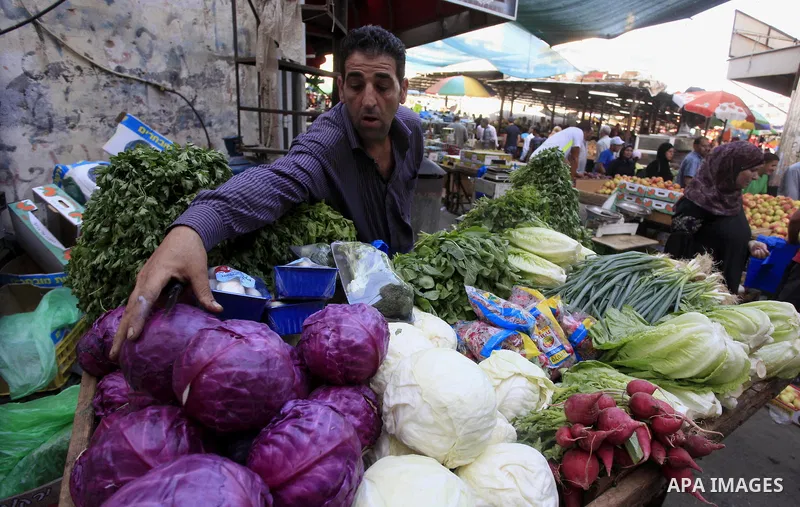 A Palestinian vendor sells vegetables in his shop at a market in the West Bank City of Ramallah, as Muslims prepare for the upcoming holy fasting month of Ramadan, on June 28, 2014. on the eve of the start of the Muslim...