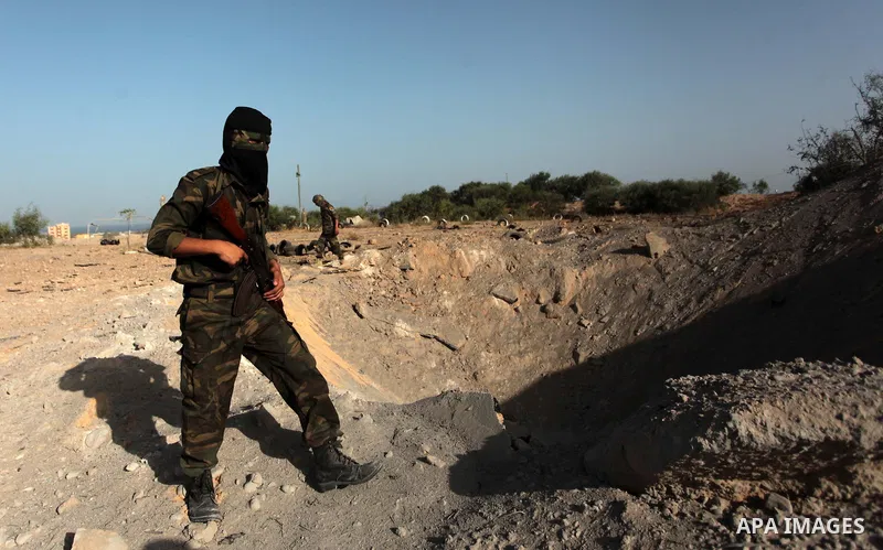 A Palestinian member of the al-Nasser Salah al-Din Brigades inspects the site following an Israeli air strike in Khan Younis in the southern Gaza strip,on June 29, 2014. Israeli warplanes launched a series of airstrikes...