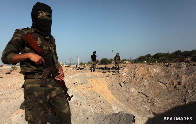 Palestinian members of the al-Nasser Salah al-Din Brigades inspect the site following an Israeli air strike in Khan Younis in the southern Gaza strip,on June 29, 2014. Israeli warplanes launched a series of airstrikes ac...