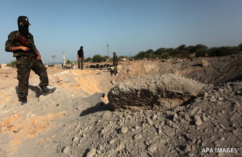 Palestinian members of the al-Nasser Salah al-Din Brigades inspect the site following an Israeli air strike in Khan Younis in the southern Gaza strip,on June 29, 2014. Israeli warplanes launched a series of airstrikes ac...