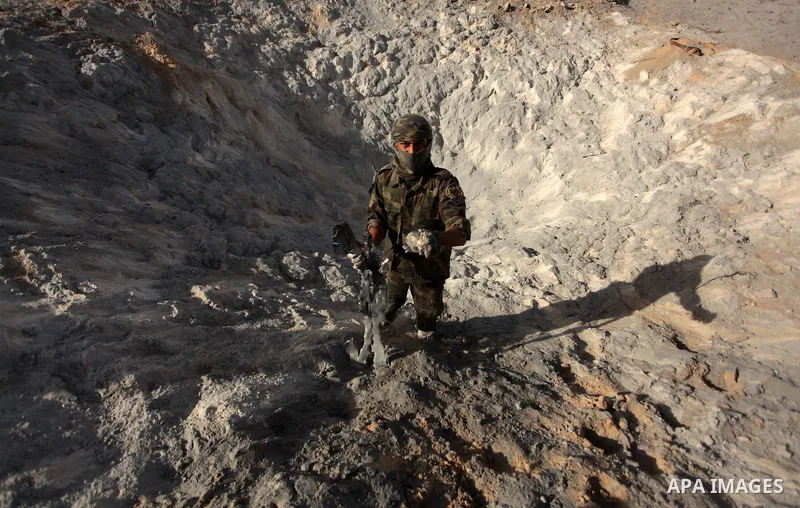 A Palestinian member of the al-Nasser Salah al-Din Brigades inspects the site following an Israeli air strike in Khan Younis in the southern Gaza strip,on June 29, 2014. Israeli warplanes launched a series of airstrikes...
