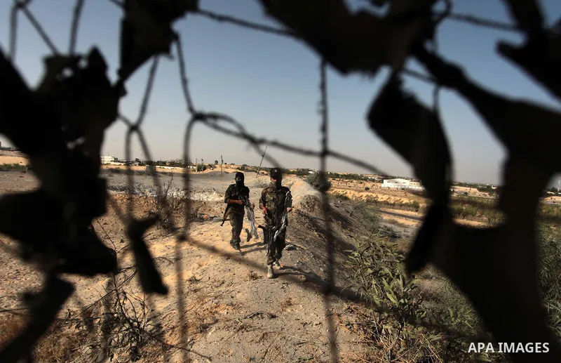 Palestinian members of the al-Nasser Salah al-Din Brigades inspect the site following an Israeli air strike in Khan Younis in the southern Gaza strip,on June 29, 2014. Israeli warplanes launched a series of airstrikes ac...