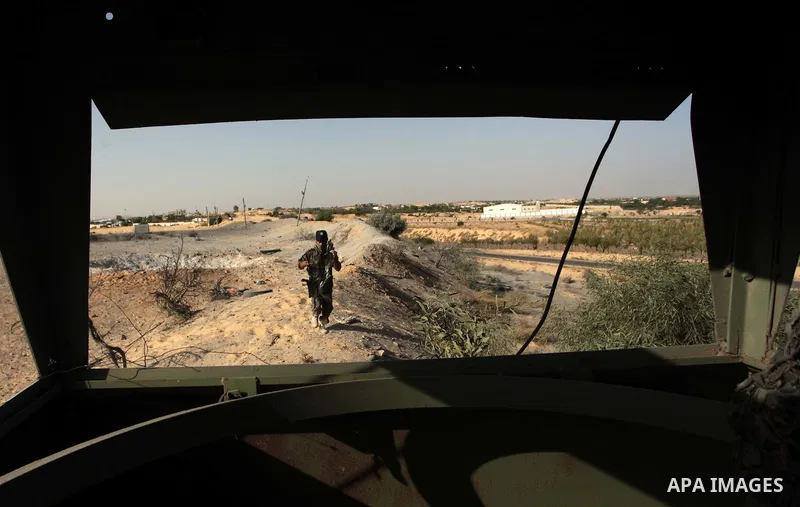 A Palestinian member of the al-Nasser Salah al-Din Brigades inspects the site following an Israeli air strike in Khan Younis in the southern Gaza strip,on June 29, 2014. Israeli warplanes launched a series of airstrikes...
