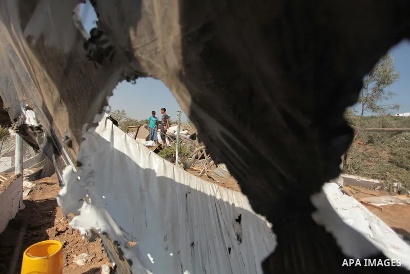 Palestinian men inspect a chicken coop damaged in an Israeli air strike in Bureij refugee camp in central Gaza Strip, on June 29, 2014. Israeli warplanes launched a series of air strikes across the Gaza Strip early Sunda...