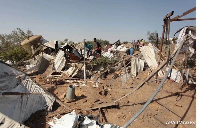 Palestinian men inspect a chicken coop damaged in an Israeli air strike in Bureij refugee camp in central Gaza Strip, on June 29, 2014. Israeli warplanes launched a series of air strikes across the Gaza Strip early Sunda...