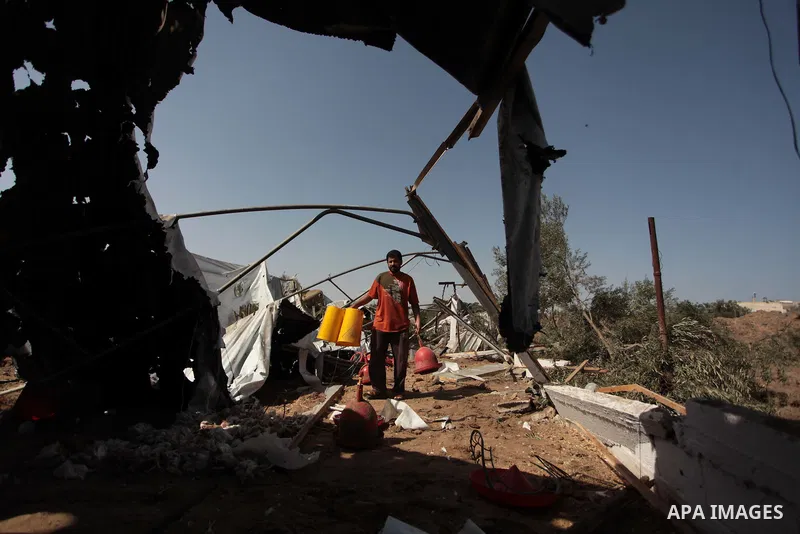 A Palestinian man inspects a chicken coop damaged in an Israeli air strike in Bureij refugee camp in central Gaza Strip, on June 29, 2014. Israeli warplanes launched a series of air strikes across the Gaza Strip early Su...