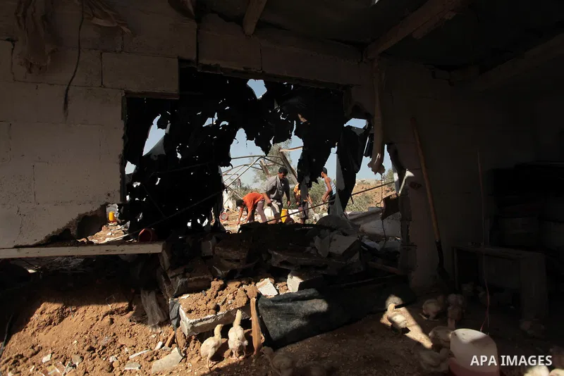 Palestinian men inspect a chicken coop damaged in an Israeli air strike in Bureij refugee camp in central Gaza Strip, on June 29, 2014. Israeli warplanes launched a series of air strikes across the Gaza Strip early Sunda...